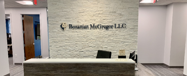 light colored brick wall with Bozanian McGregor sign at the office