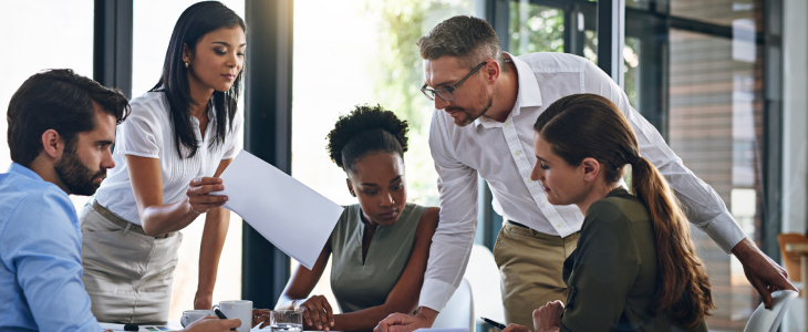 Diverse team of professionals work around a desk